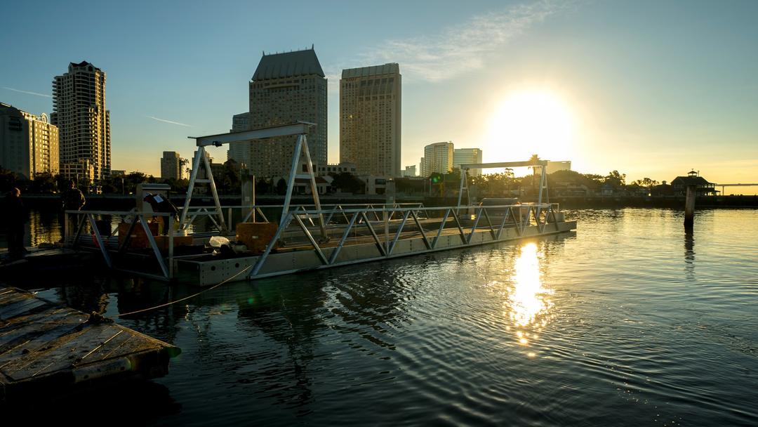 The sun rises over Downtown San Diego and illuminates the bay and highlights the FLUPSY