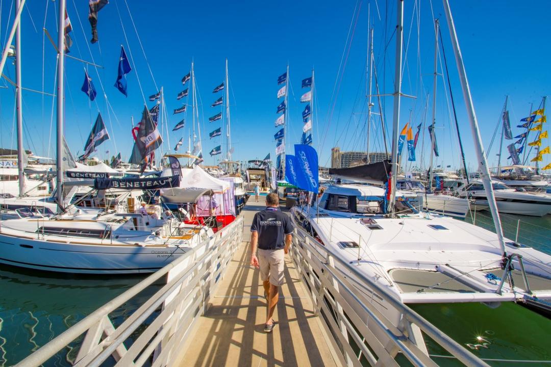 a man walks down a ramp towards the docks and boats