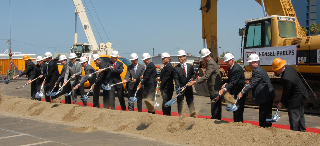 Ribbon cutting ceremony at Lane Field. a long like of VIPs shovel dirt