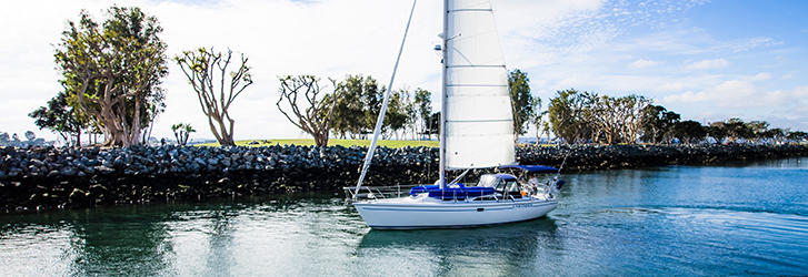 a small, white sailboat sailing on the San Diego Bay