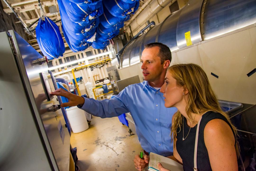 two people inspect environmental installations