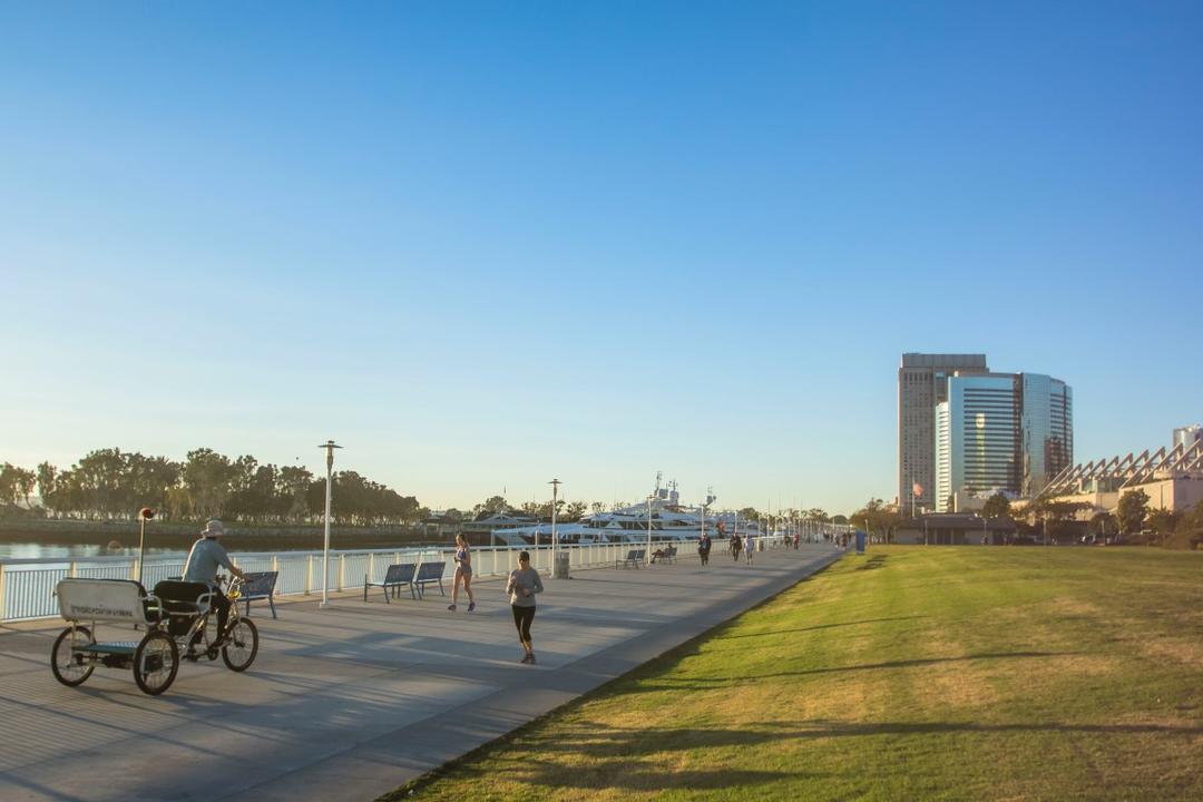 People running and cycling along the bay at San Diego Bayfront Park at the Port of San Diego