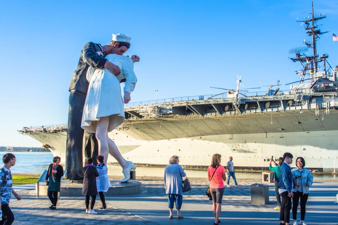 Embracing Peace painted sculpture by Seward Johnson in front of USS Midway at Tuna Harbor Park at the Port of San Diego