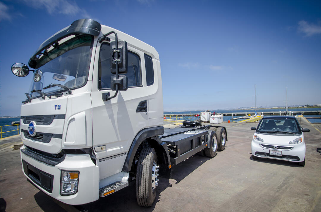 An electric truck and small vehicle parked side by side