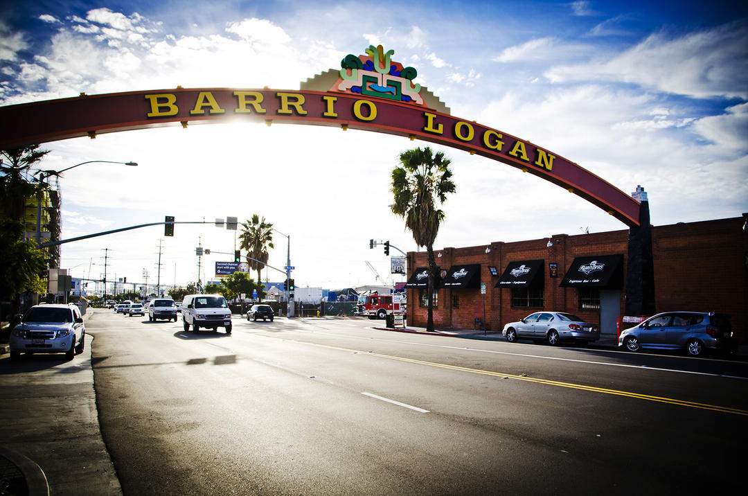 a partially cloudy day photo of the Barrio Logan Gateway sign