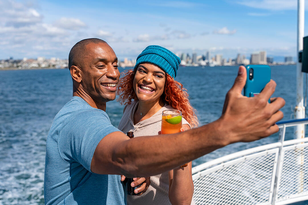 A couple takes a selfie on San Diego Bay with the city in the background - 2019