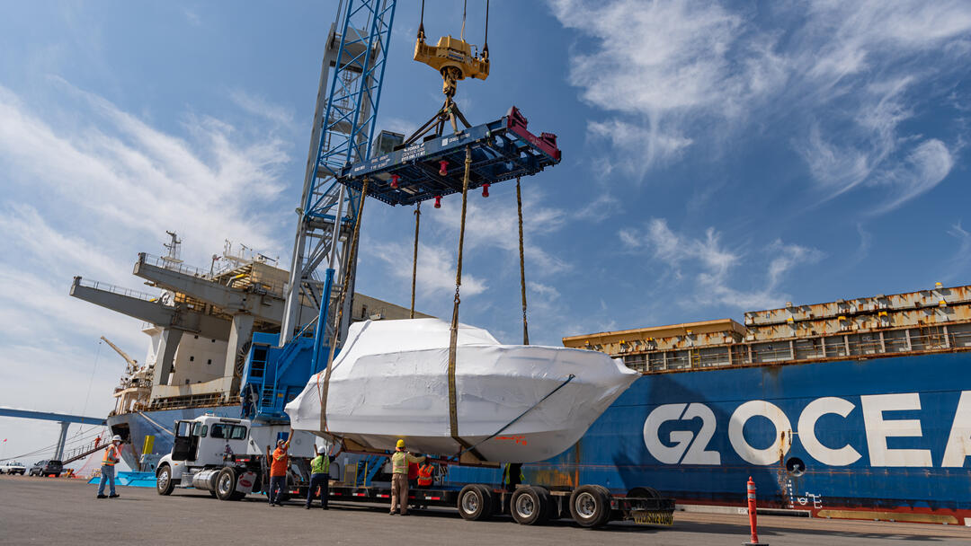 a cargo ship unloads a boat at the Port of San Diego