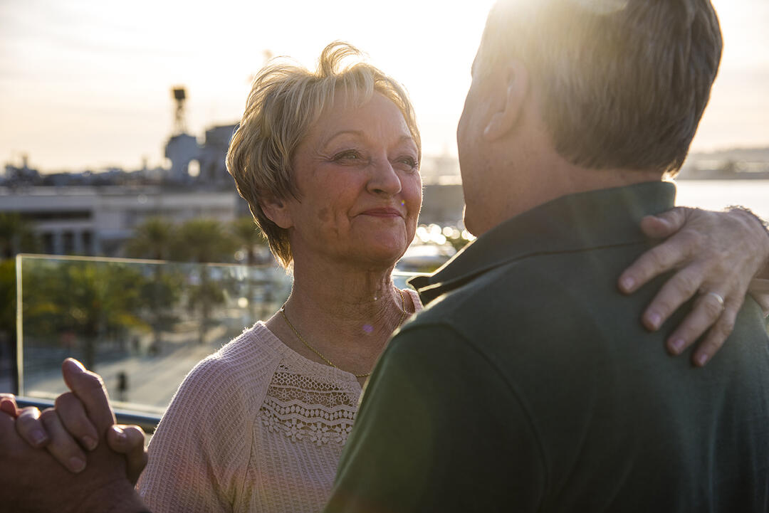 a couple dances as the sun sets over the San Diego Bay