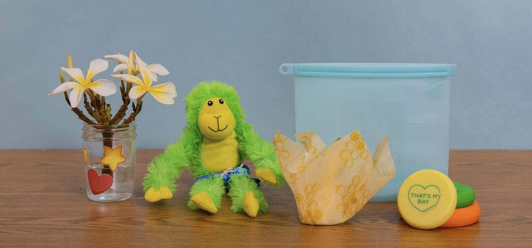 a little green monkey poses with reused items