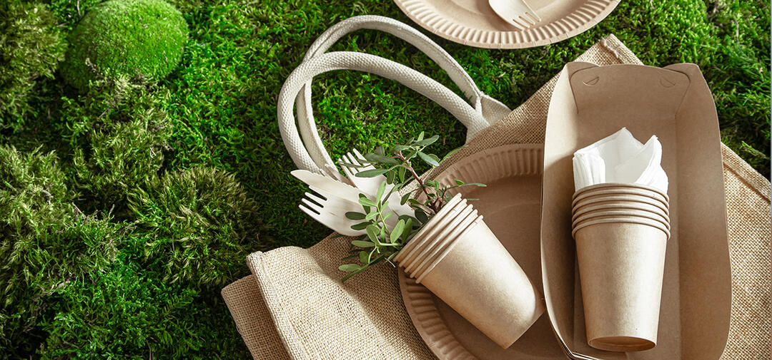 recyclable items - cups and totes, on a grassy background