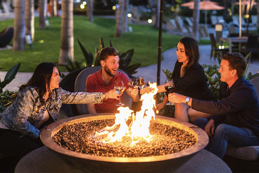 four people share a toast around a firepit at the Marriot Marquis San Diego