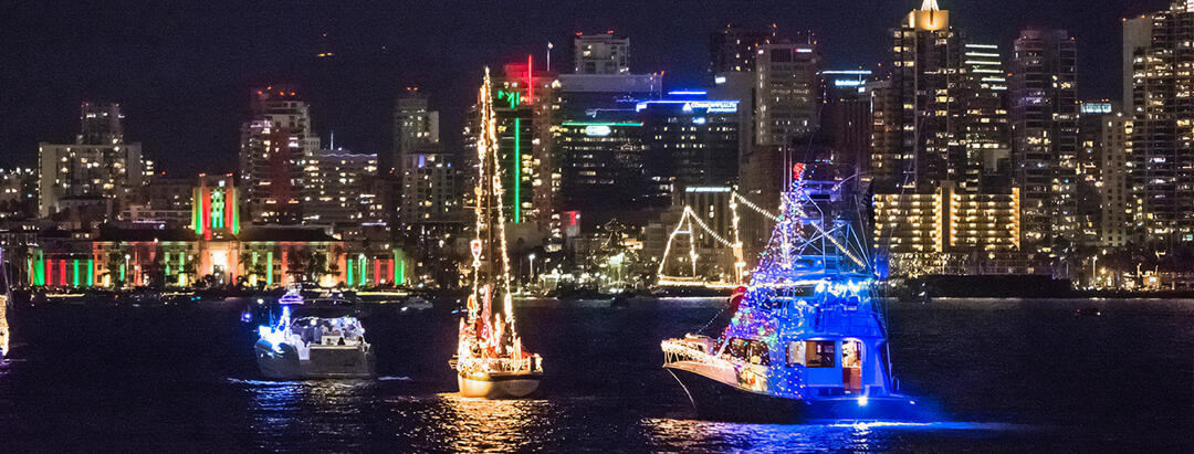 boats are decorated and lit on San Diego Bay at night.