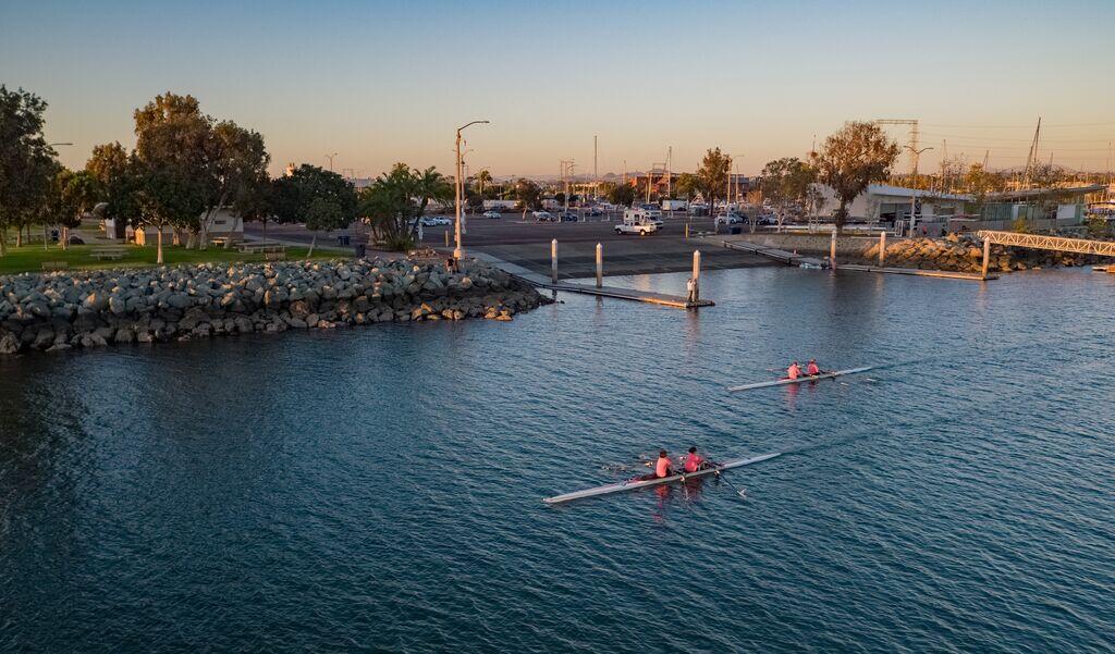 a rower skims across the water next to Pepper Park