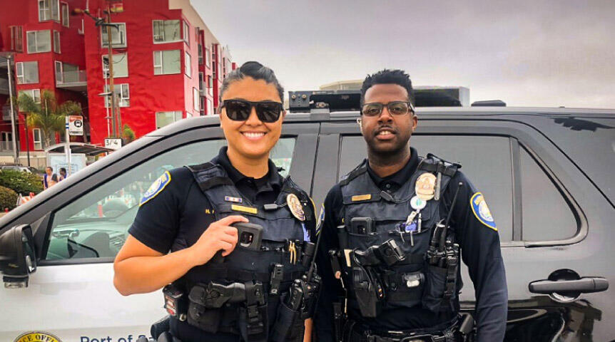 Two Port of San Diego harbor Police officers standing in front of car