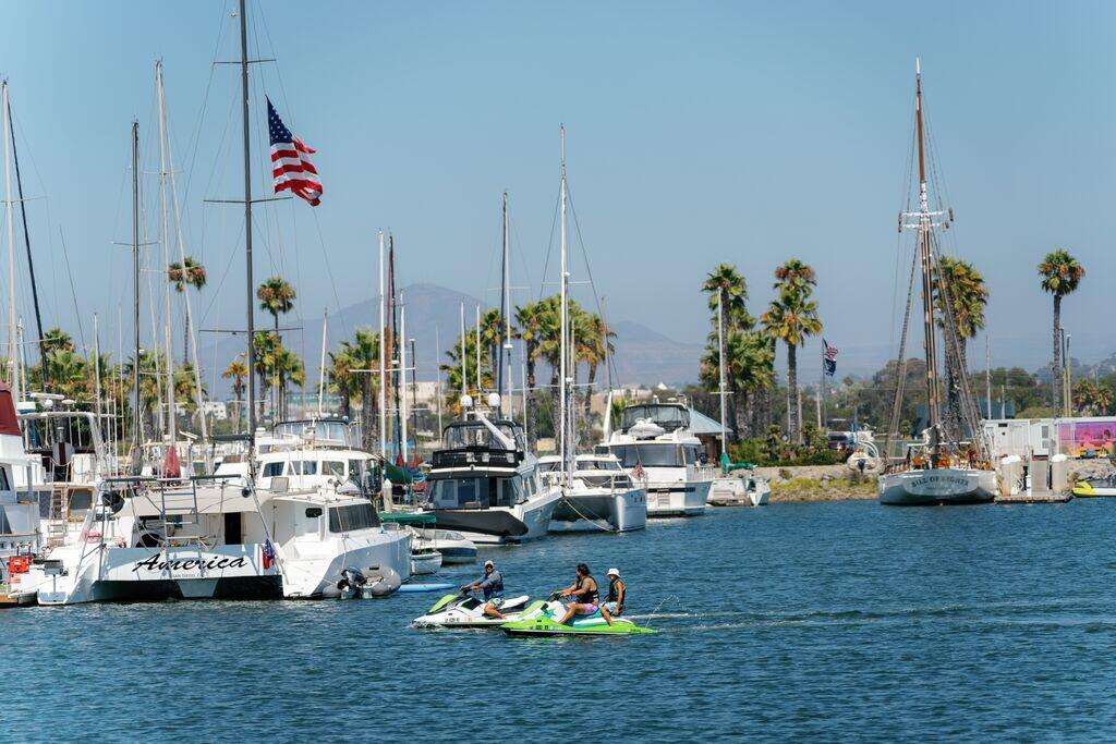 Image of jet skiers in San Diego Bay near Chula Vista with boats docked at the marina.