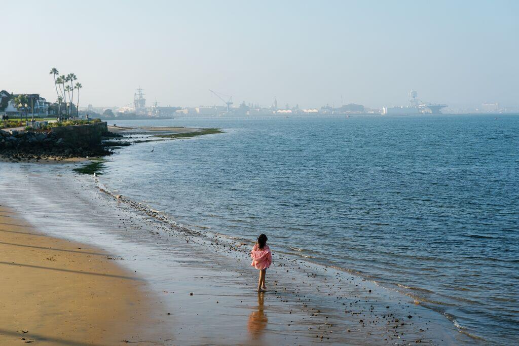 a girl walks along the beach at the park