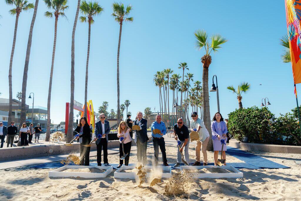 Group of people holding shovels.