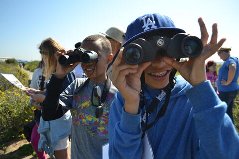 Children looking through binoculars.