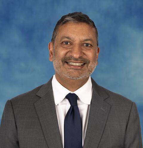 Portrait of Port of San Diego Commissioner Sid Voorakkara with a blue background.