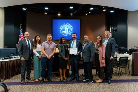 Photo in the Port boardroom, with the Port seal in the background, of Port Board members, staff and Circulate San Diego Board members and staff..