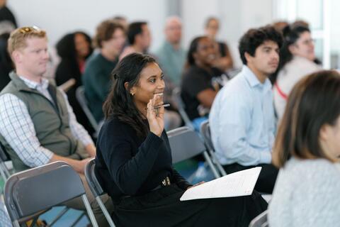 Woman in audience raising hand
