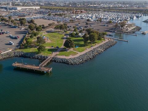 Aerial of marina area in National City with water, green park space, and boats in a marina.
