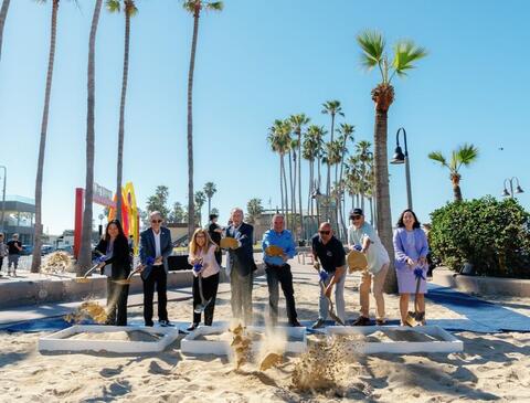 Group of people holding shovels.