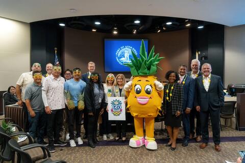 Port of San Diego and Dole representatives pose in the Port's Boardroom with Pinellopy the Pineapple, Dole's healthy-living mascot.
