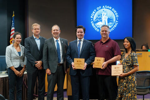 Four men and two women holding an award