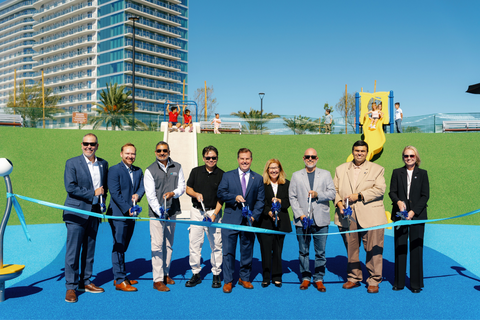 Adults holding scissors for a ribbon cutting ceremony at Harbor Park Playground in Chula Vista