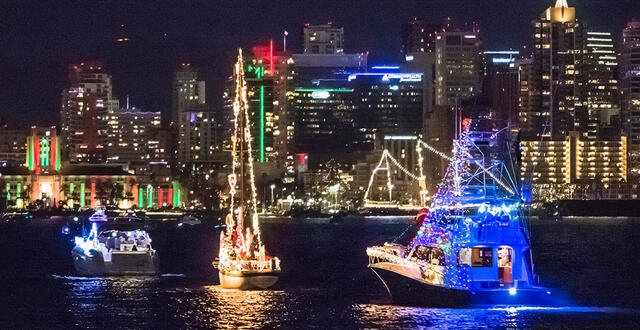 boats are decorated and lit on San Diego Bay at night.