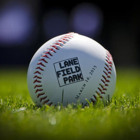 A Lane Field Park baseball sits atop the grass.