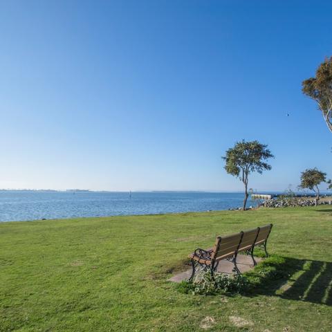 Bench on grass overlooking water at Chula Vista Bayside Park at the Port of San Diego
