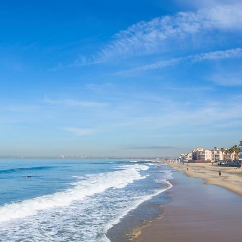 Imperial Beach sandy shore and waves under blue skies at Portwood Pier Plaza at the Port of San Diego