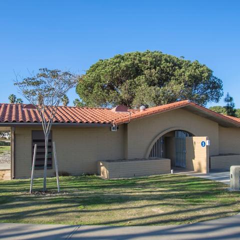 Restroom surrounded by grass and trees at Spanish Landing Park at the Port of San Diego