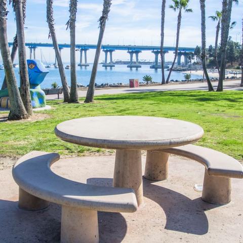 Picnic table, grass, trees, and view of San Diego-Coronado Bay Bridge at Coronado Tidelands Park at the Port of San Diego