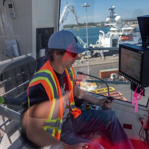 a man operates a crane at the Port of San Diego