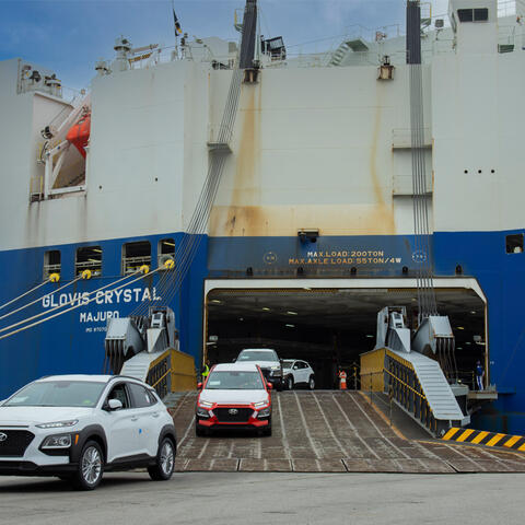 cars are driven off of a roll-on, roll-off  (ro-ro) cargo ship named Glovis Crystal