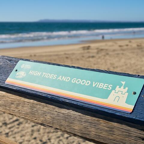 Teal sign on the IB Pier says "High Tides Good Vibes"