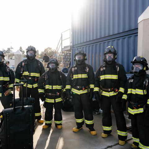 six people wearing helmets, facemasks, and protective gear