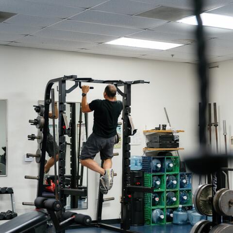 a person does pullups at a gym