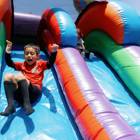 a kid slides down an inflatable slide 