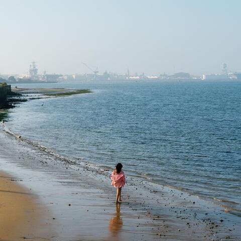 a girl walks along the beach at the park